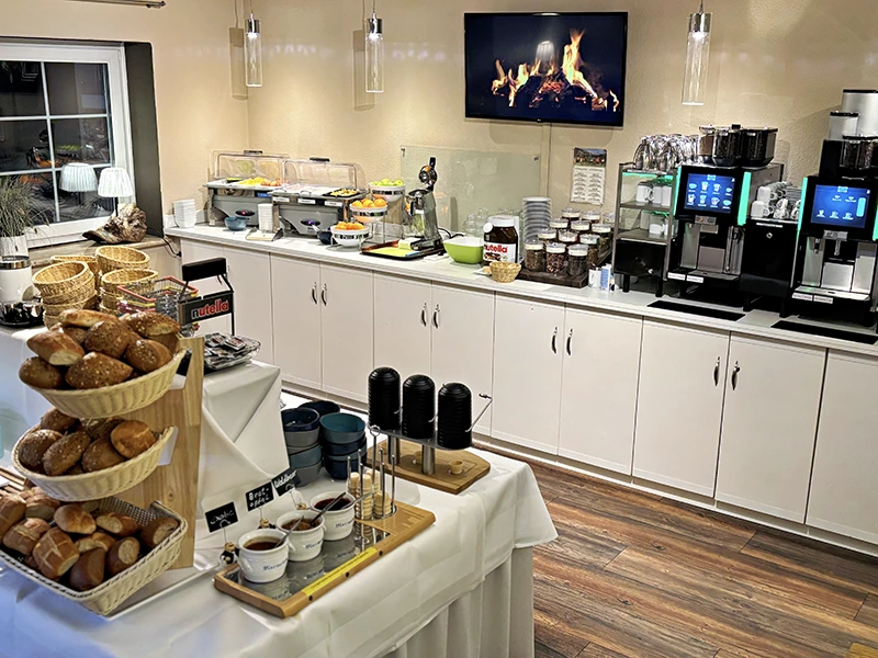 Mit frischen Brötchen, Brot und Marmeladen.